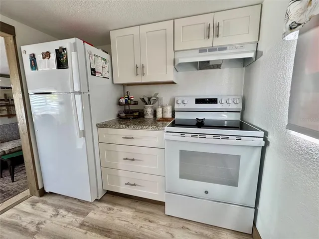 a kitchen with white cabinets stainless steel appliances and sink