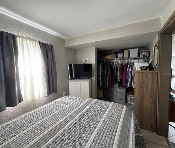 a bedroom with a bed and a television