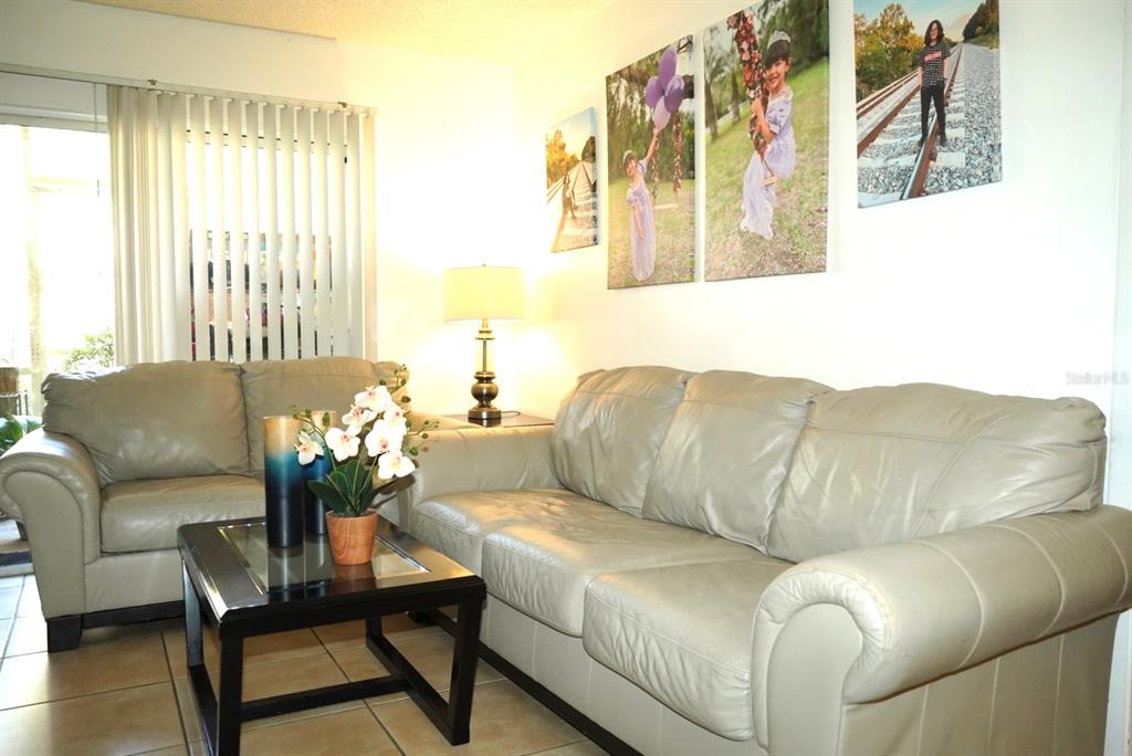1664 Sunny Brook Lane, Unit 103 Palm Bay, FL 32905 - Photo 2 of 10 a living room with furniture and a large window
