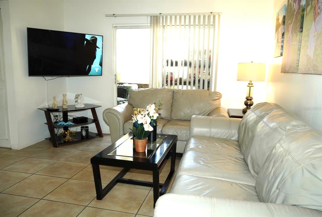 1664 Sunny Brook Lane, Unit 103 Palm Bay, FL 32905 - Photo 3 of 10 a living room with furniture and a flat screen tv