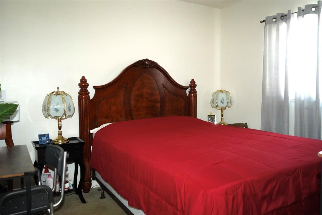 1664 Sunny Brook Lane, Unit 103 Palm Bay, FL 32905 - Photo 6 of 10 a bedroom with a bed and a chandelier