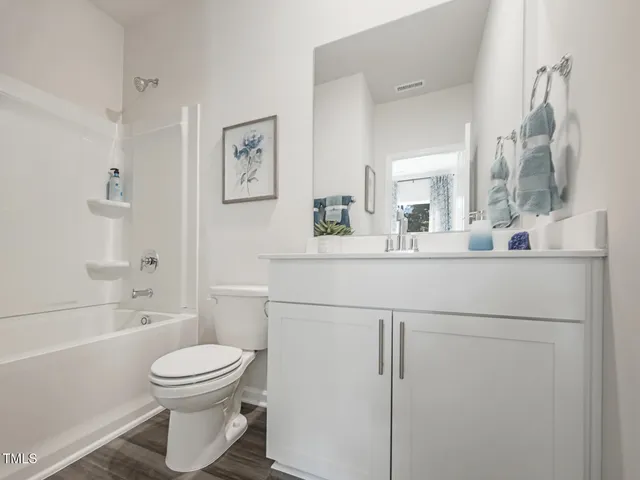 a spacious bedroom with a bed a couch and a view of en suite bathroom