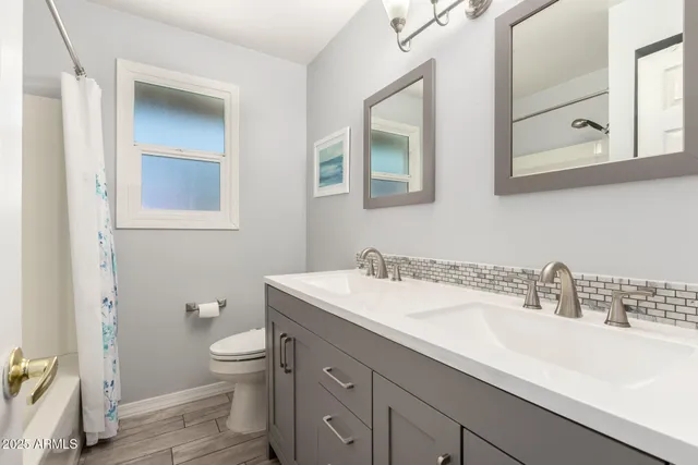 a patio with a table and chairs and potted plants