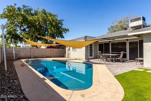 a backyard of a house with table and chairs and potted plants