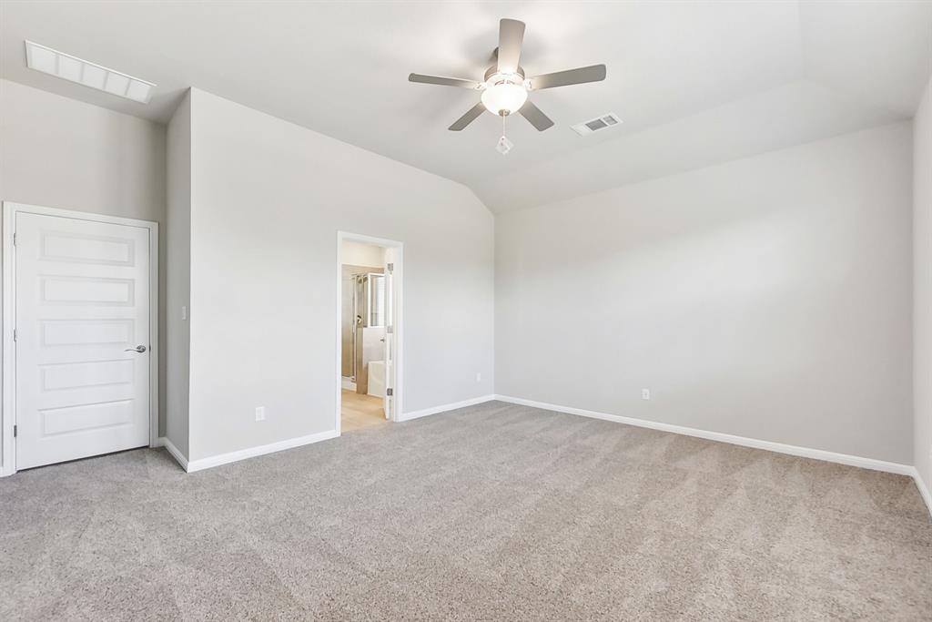 181 Old Town Road Kyle, TX 78640 - Photo 28 of 32 Plush carpeting and vaulted ceilings enhance this spacious bedroom, offering an adjoining private bath.