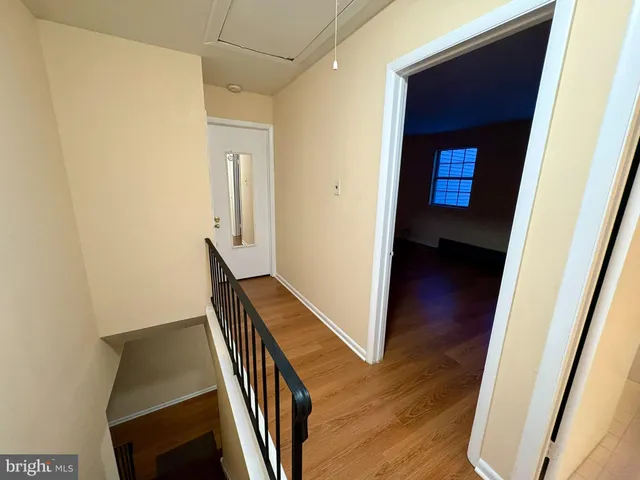 a view of a hallway with wooden floor and stairs