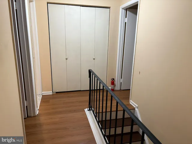 a view of a hallway with wooden floor and staircase