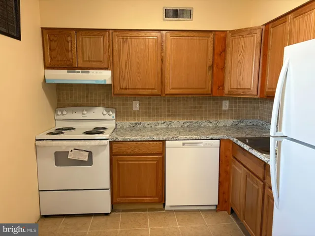 a kitchen with a stove a sink and a refrigerator