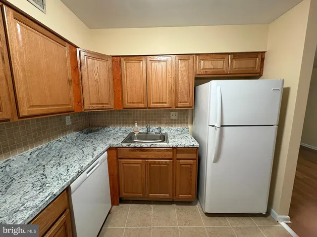 a kitchen with stainless steel appliances granite countertop a refrigerator and a stove