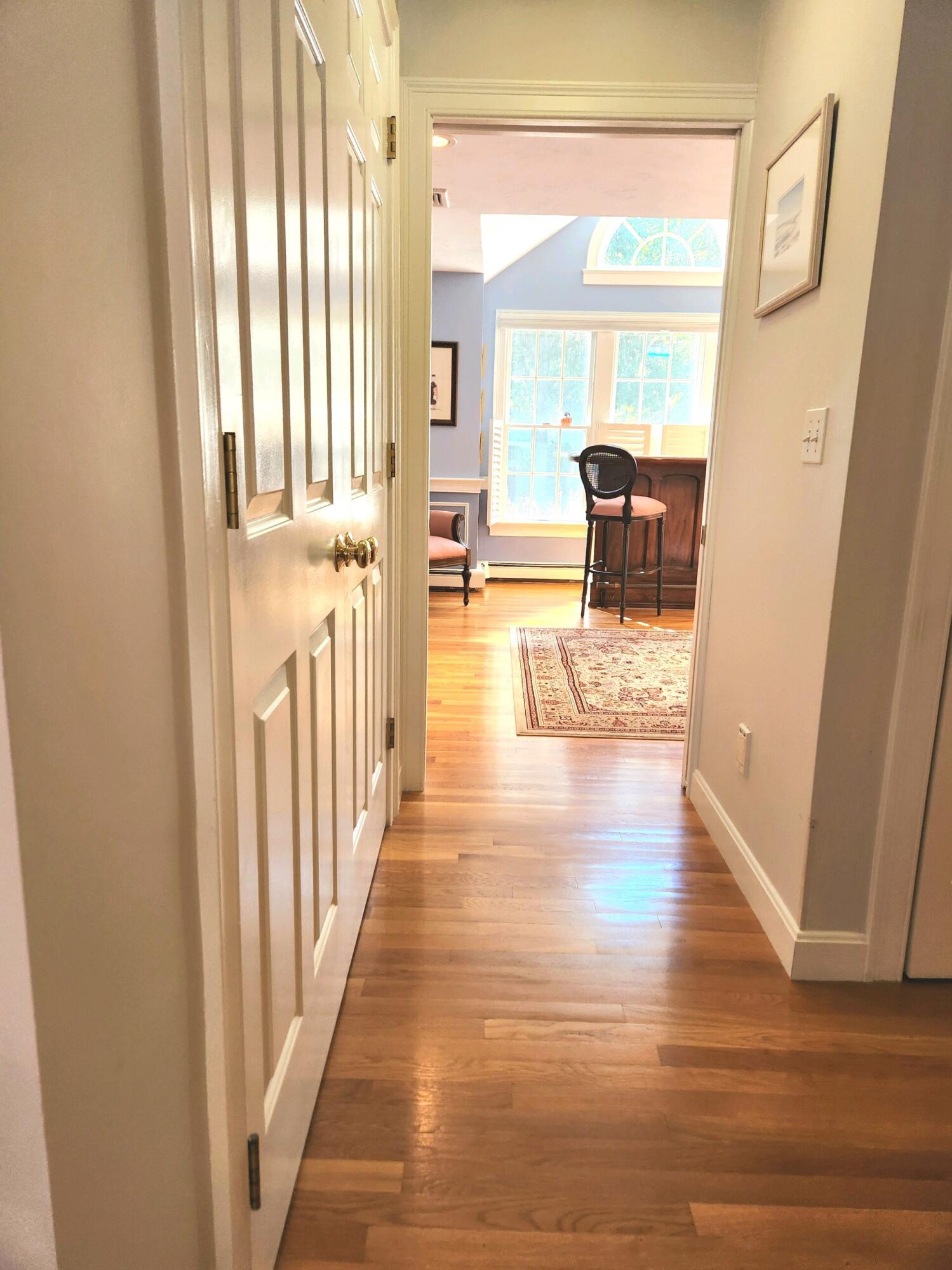 155 Far Fields Road Brewster, MA 02631 - Photo 16 of 40 a view of a hallway with wooden floor and windows