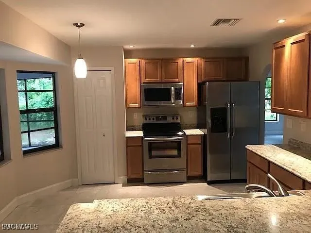 a kitchen with a refrigerator and a stove top oven