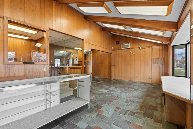 a view of a hallway with furniture and a window