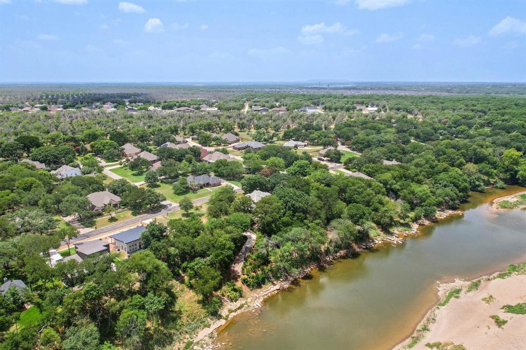 7818 Ravenswood Road Granbury, TX 76049 - Photo 2 of 2 Expansive aerial showcasing a residential area bordered by a river and extensive tree coverage