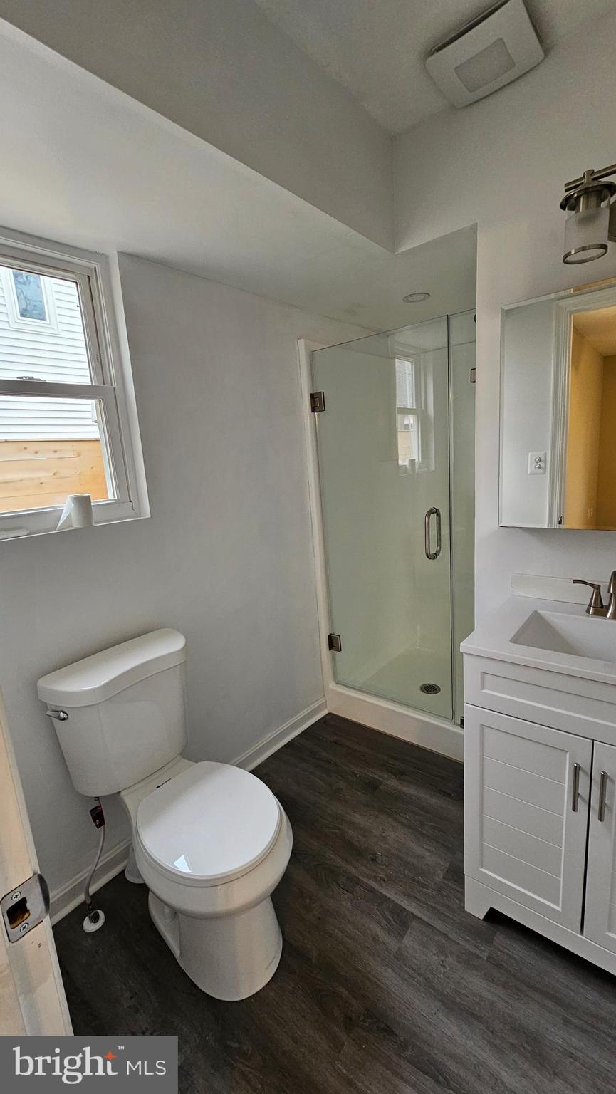 654 Emmett Place North Beach, MD 20714 - Photo 16 of 24 a bathroom with a toilet a sink and wooden floor