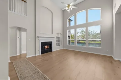 a view of an empty room with a fireplace and a window