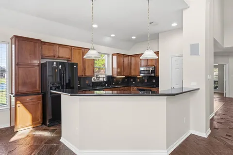 a kitchen with stainless steel appliances granite countertop a refrigerator and a stove