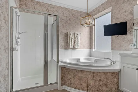 a bathroom with a granite countertop sink a mirror and shower