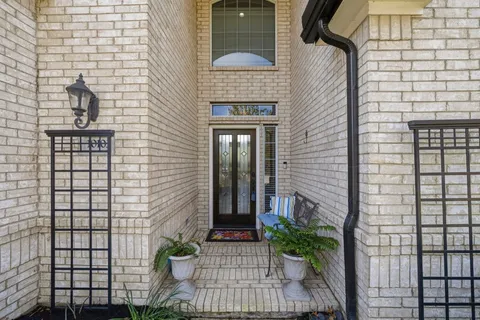 a view of a brick house with potted plants