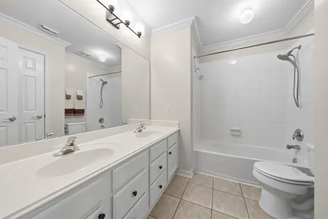 a bathroom with a double vanity sink toilet mirror and shower
