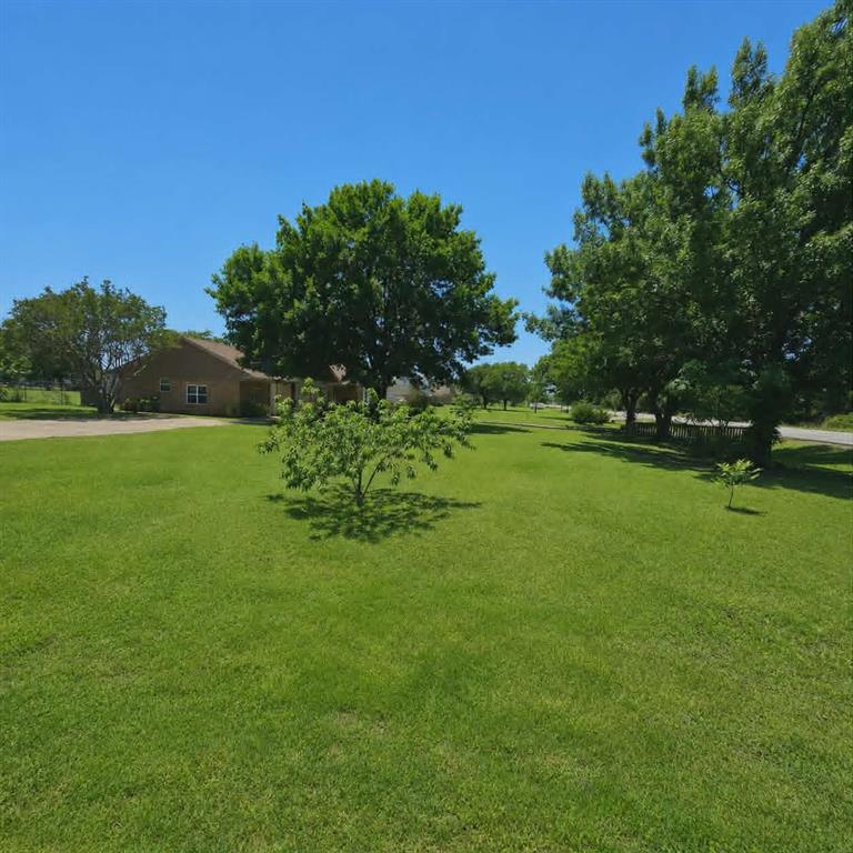 14752 Ranch Road Forney, TX 75126 - Photo 40 of 40 Expansive green lawn with mature trees and a single-story brick exterior home