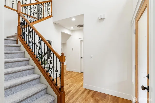a view of a hallway with wooden floor and entryway