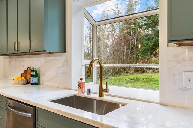 a kitchen with a sink a counter top space appliances and cabinets