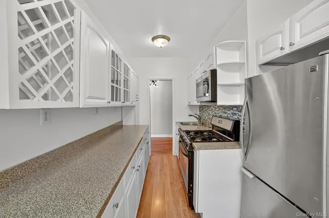a kitchen with granite countertop a refrigerator stove and sink