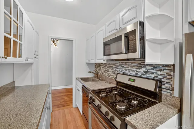 a kitchen with stainless steel appliances granite countertop a stove and a microwave