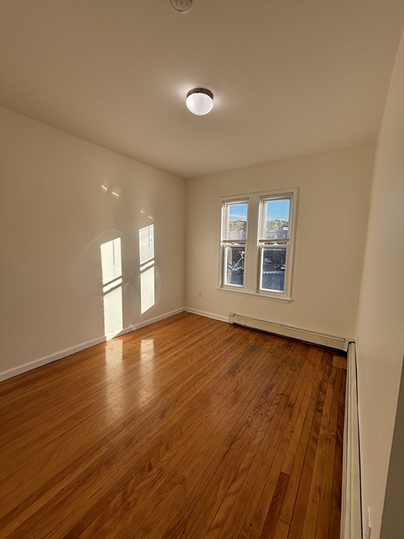 1371 Commonwealth Avenue, Unit 3 Boston, MA 02134 - Photo 7 of 8 wooden floor in an empty room with a window