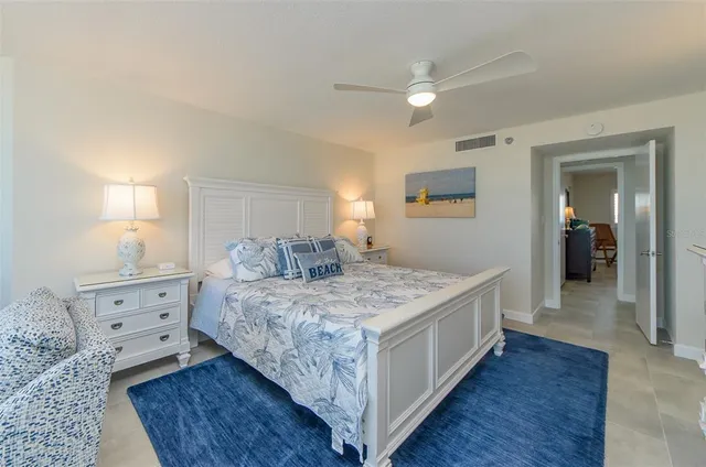 a large bedroom with a bed and wooden floor