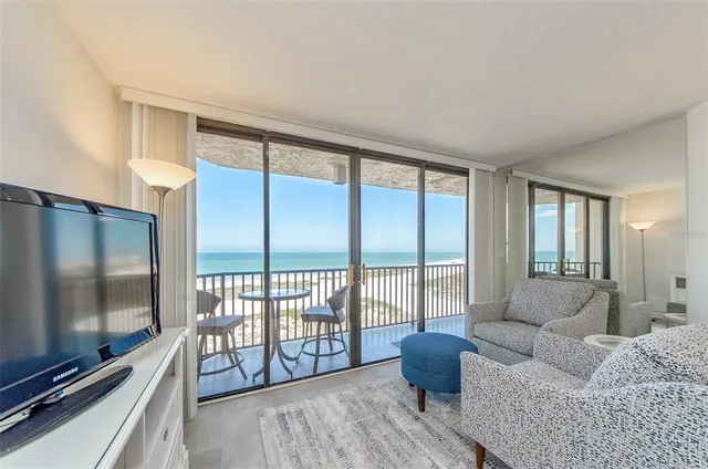 a living room with furniture tv and a floor to ceiling window
