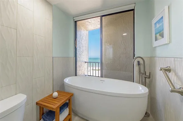a white toilet sitting next to a bathroom sink and tub