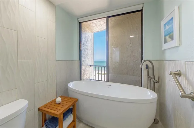 a white toilet sitting next to a bathroom sink and tub