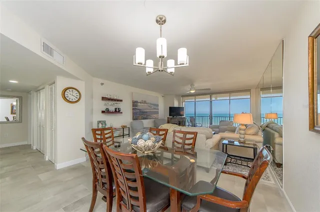 a view of a dining room with furniture a chandelier and wooden floor