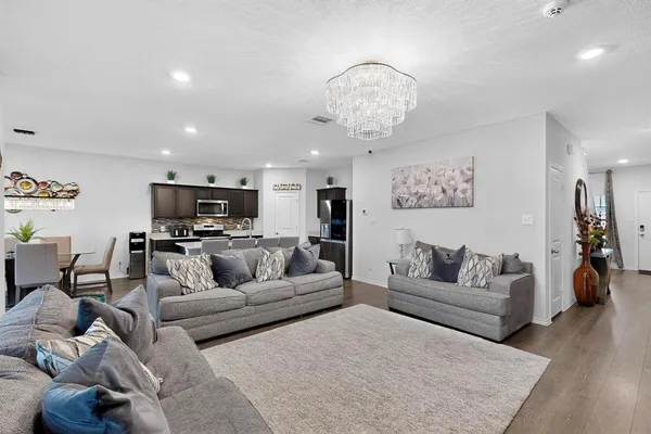 a living room with furniture and kitchen view
