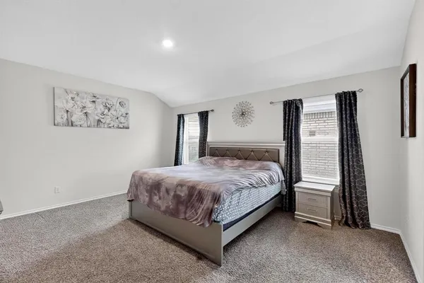a bedroom with a bed lamp and a large window