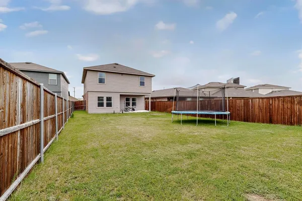 a view of a house with backyard and wooden fence