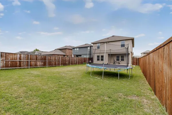 a view of house with a big yard and large trees