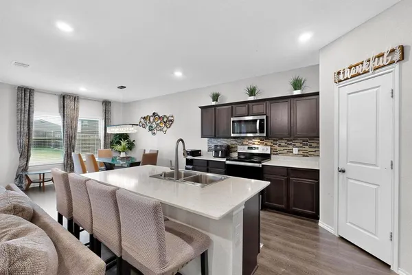 a kitchen with a sink a microwave a refrigerator and cabinets