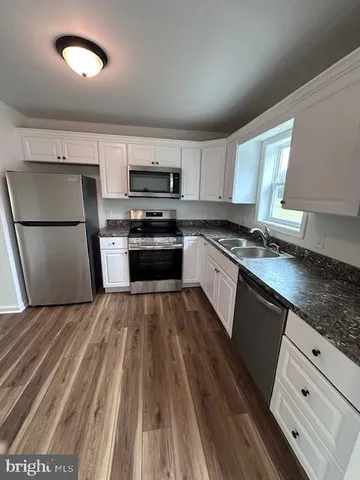 a kitchen with kitchen island granite countertop a refrigerator stove top oven and sink