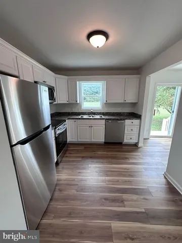 a kitchen with stainless steel appliances granite countertop a refrigerator sink and stove