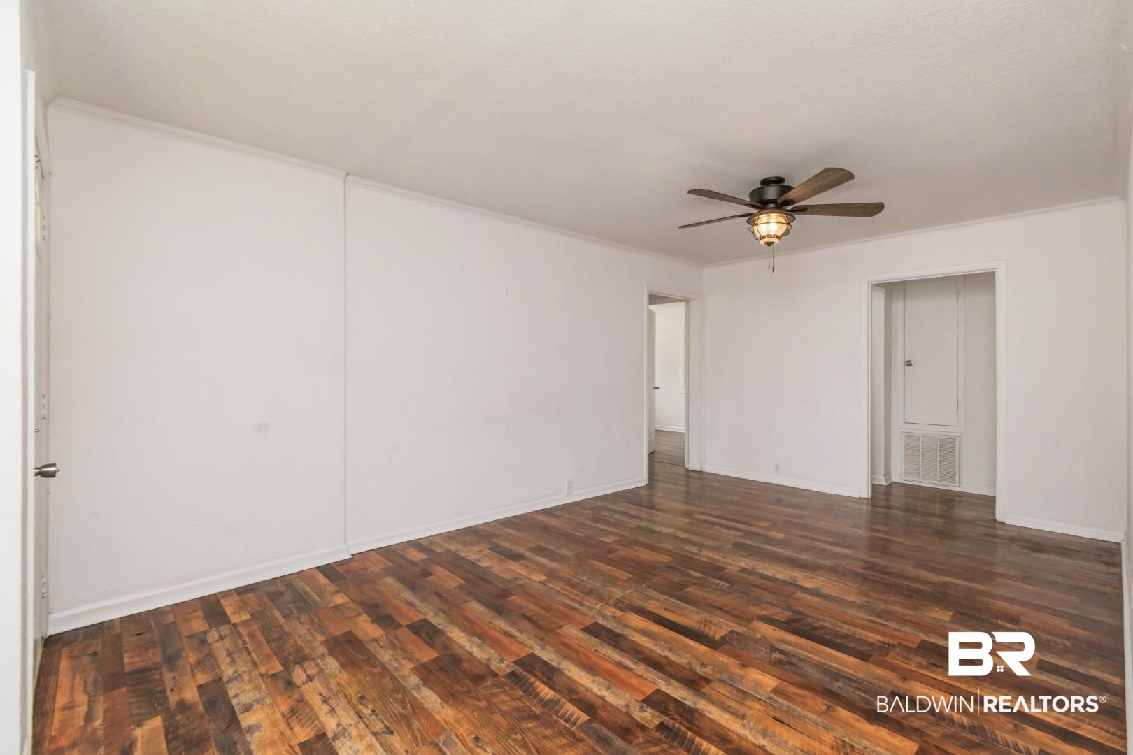 2905A McFarland Road, Unit F Mobile, AL 36695 - Photo 6 of 29 Spacious room featuring wood-finish flooring, crisp white walls, and a ceiling fan with integrated lighting