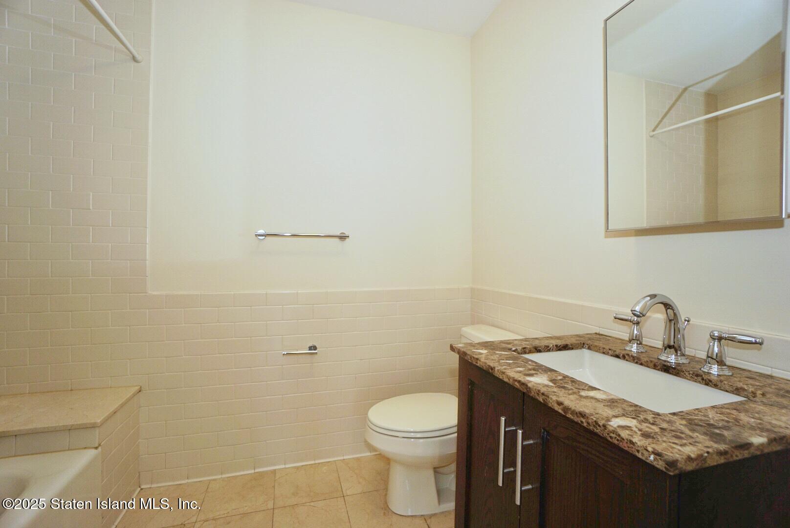 90 Bay Street Landing, Unit 4B Staten Island, NY 10301 - Photo 15 of 42 a bathroom with a granite countertop sink and a toilet