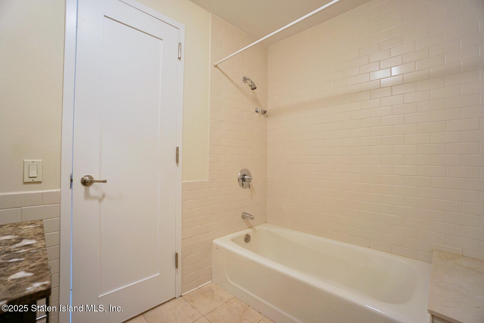 90 Bay Street Landing, Unit 4B Staten Island, NY 10301 - Photo 16 of 42 a bathroom with a tub shower and a sink
