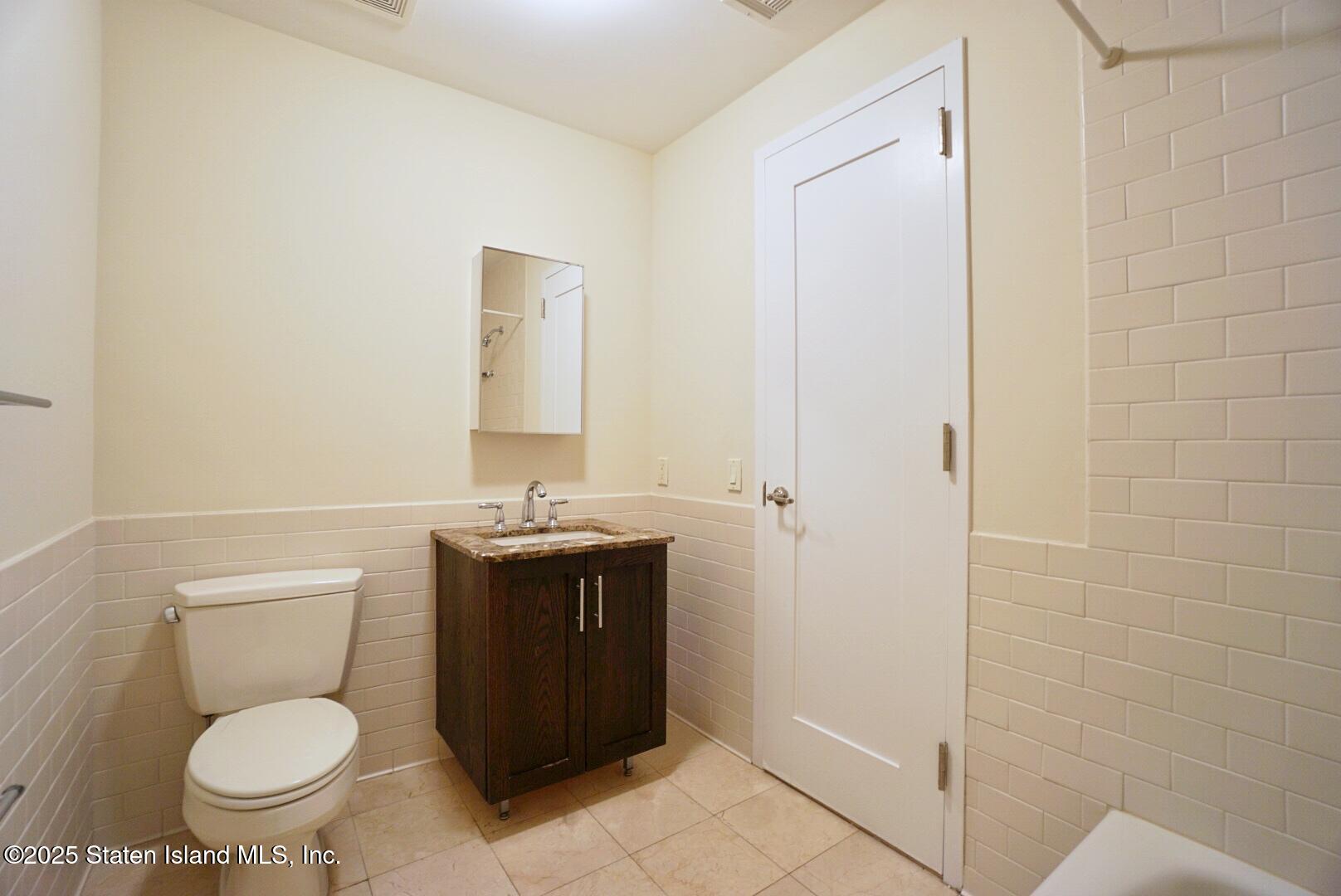 90 Bay Street Landing, Unit 4B Staten Island, NY 10301 - Photo 17 of 42 a bathroom with a granite countertop toilet and a sink