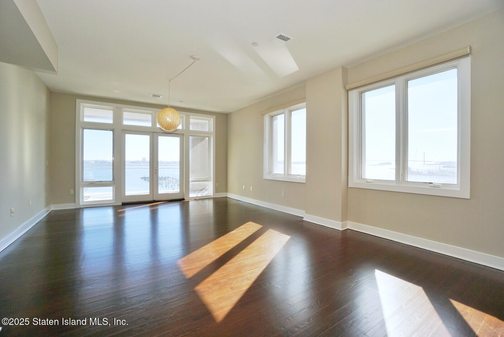 90 Bay Street Landing, Unit 4B Staten Island, NY 10301 - Photo 20 of 42 a view of an empty room with wooden floor and a window