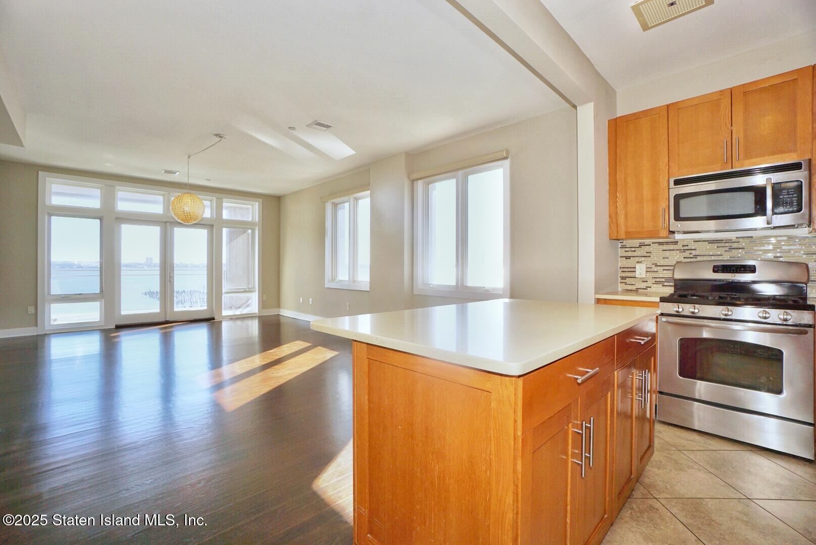 90 Bay Street Landing, Unit 4B Staten Island, NY 10301 - Photo 27 of 42 a kitchen with stainless steel appliances granite countertop a stove a sink and a refrigerator