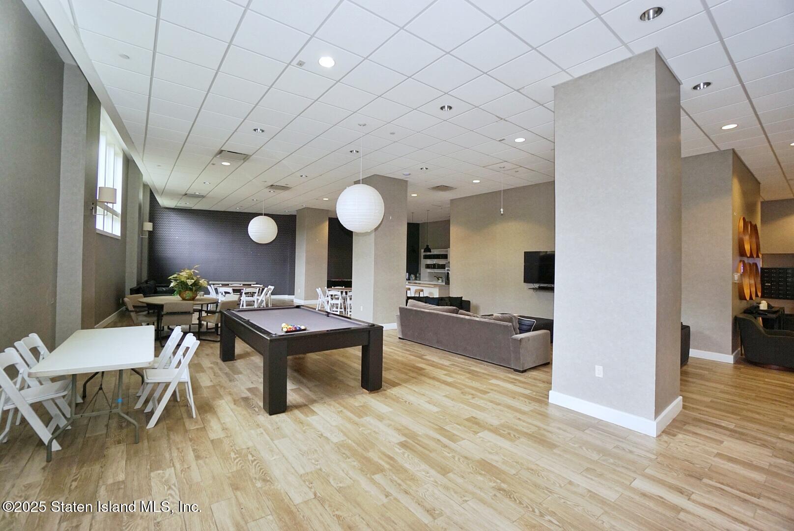 90 Bay Street Landing, Unit 4B Staten Island, NY 10301 - Photo 40 of 42 a living room with furniture a wooden floor and a chandelier