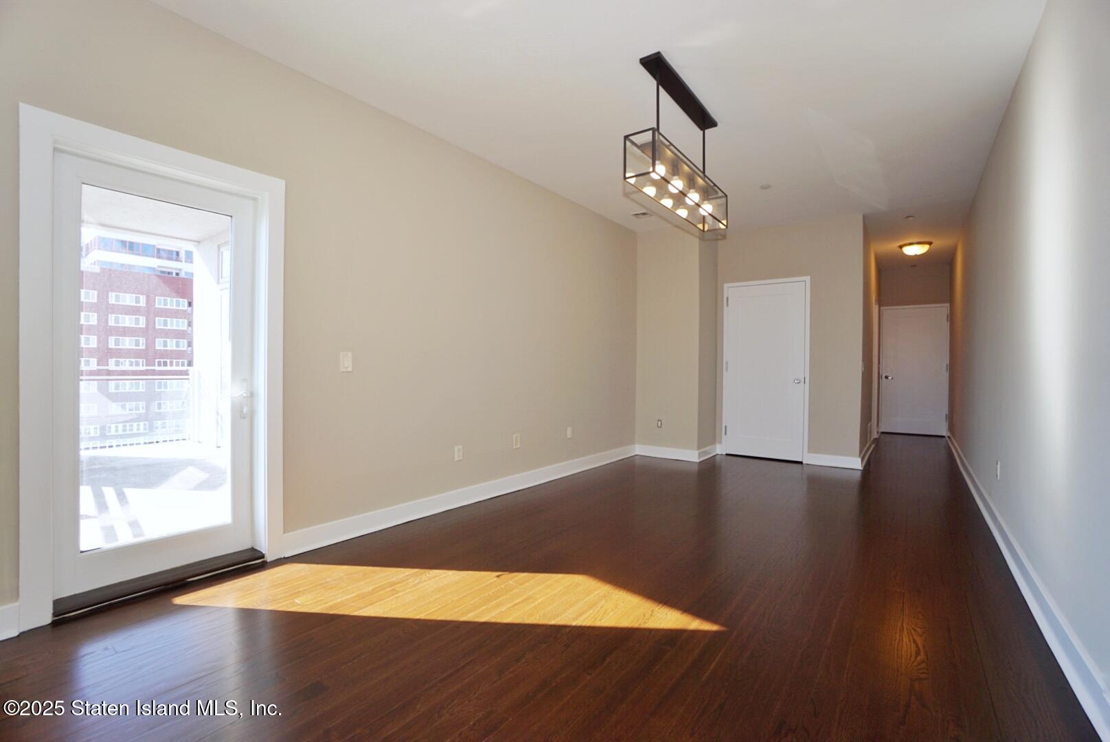 90 Bay Street Landing, Unit 4B Staten Island, NY 10301 - Photo 6 of 42 a view of an empty room with wooden floor and a window