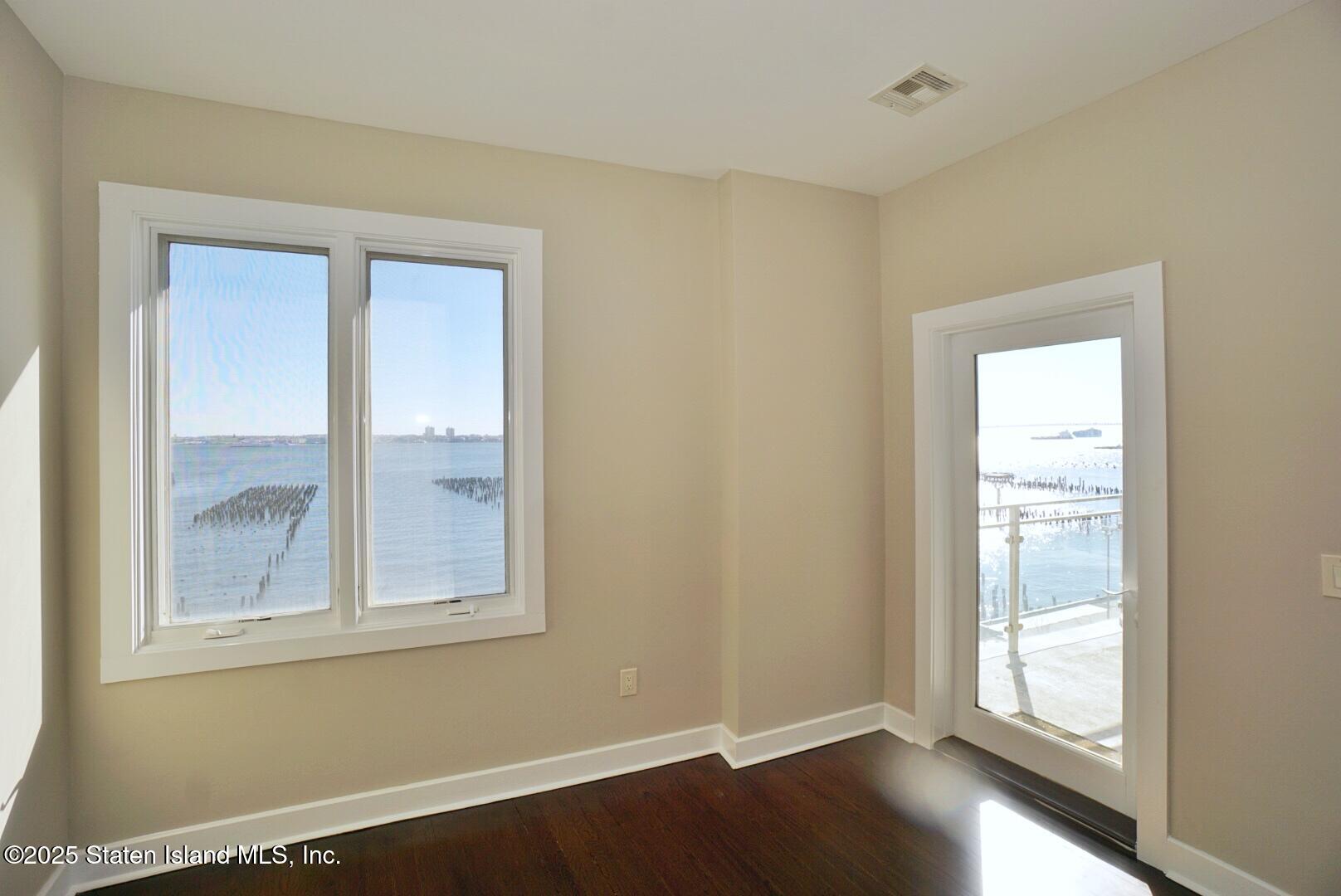 90 Bay Street Landing, Unit 4B Staten Island, NY 10301 - Photo 8 of 42 a view of an empty room with wooden floor and a window